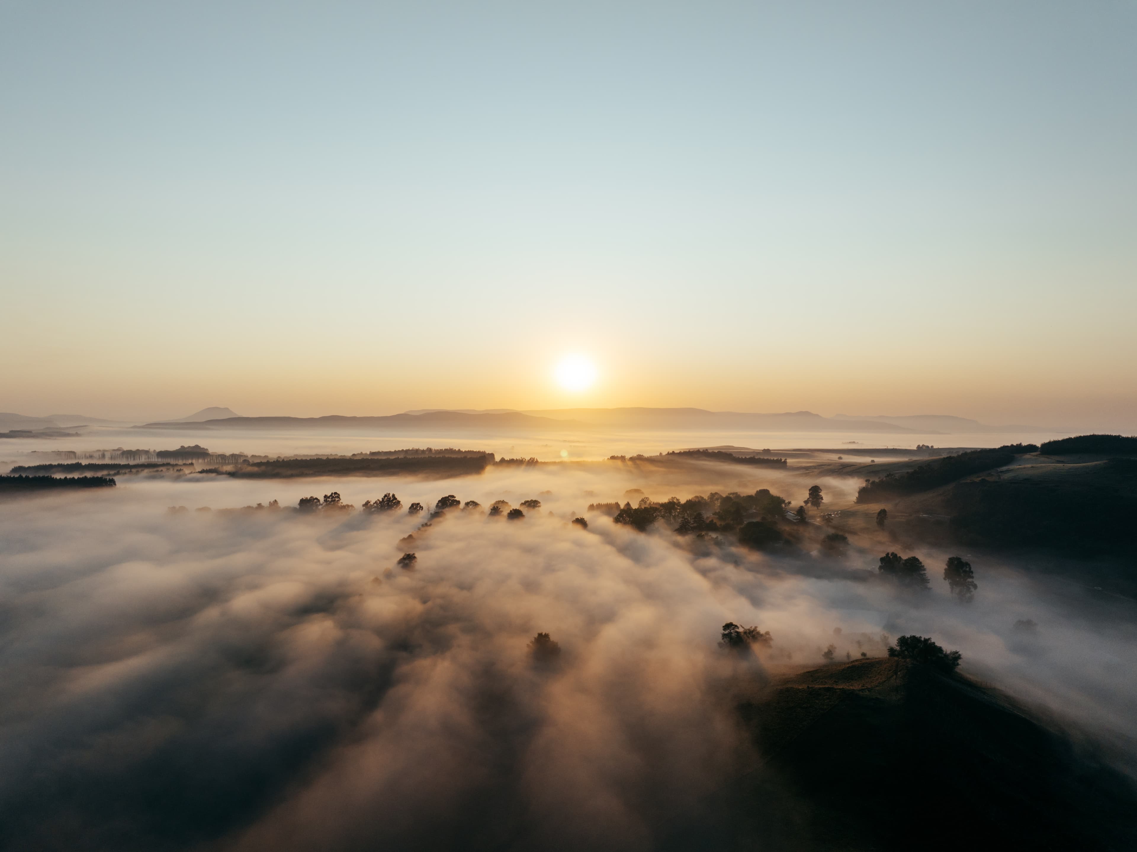 Aerial sunrise over misty valley