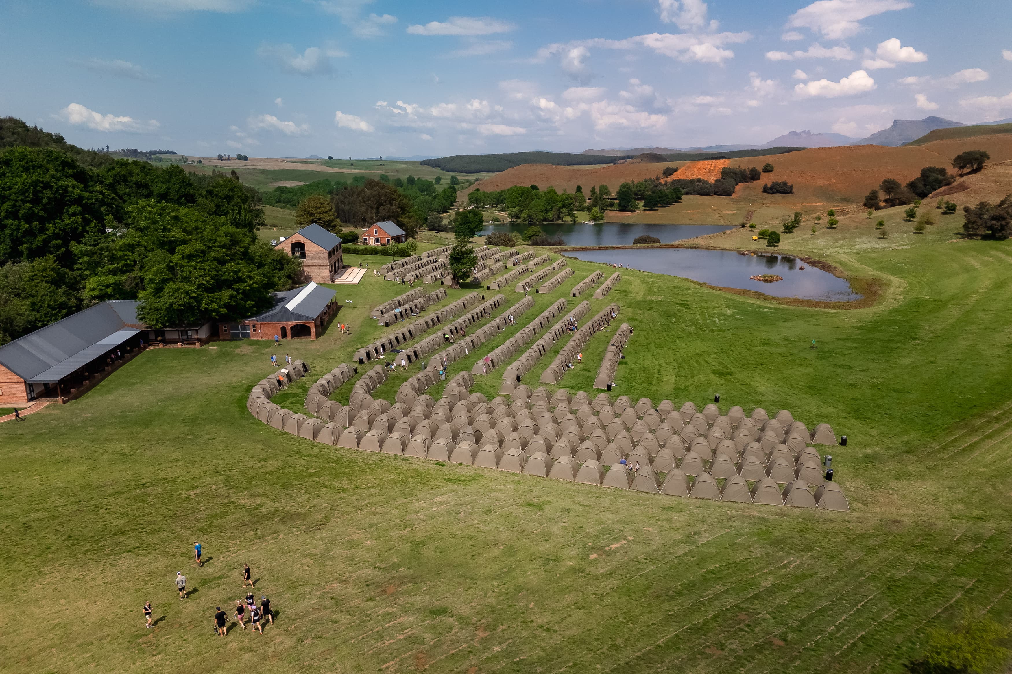 Aerial view of tent village with mountains and dam