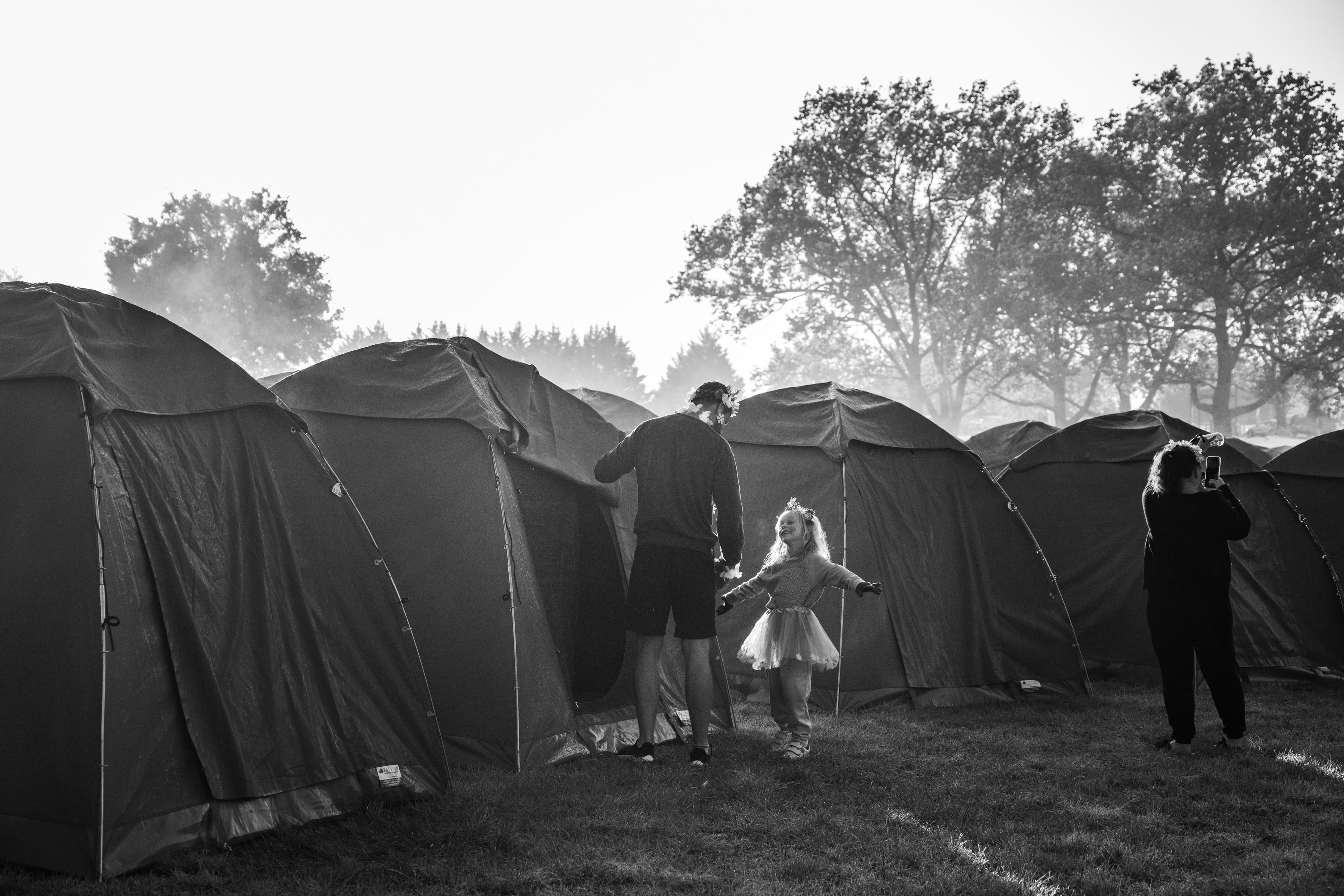Family in morning mist near tents