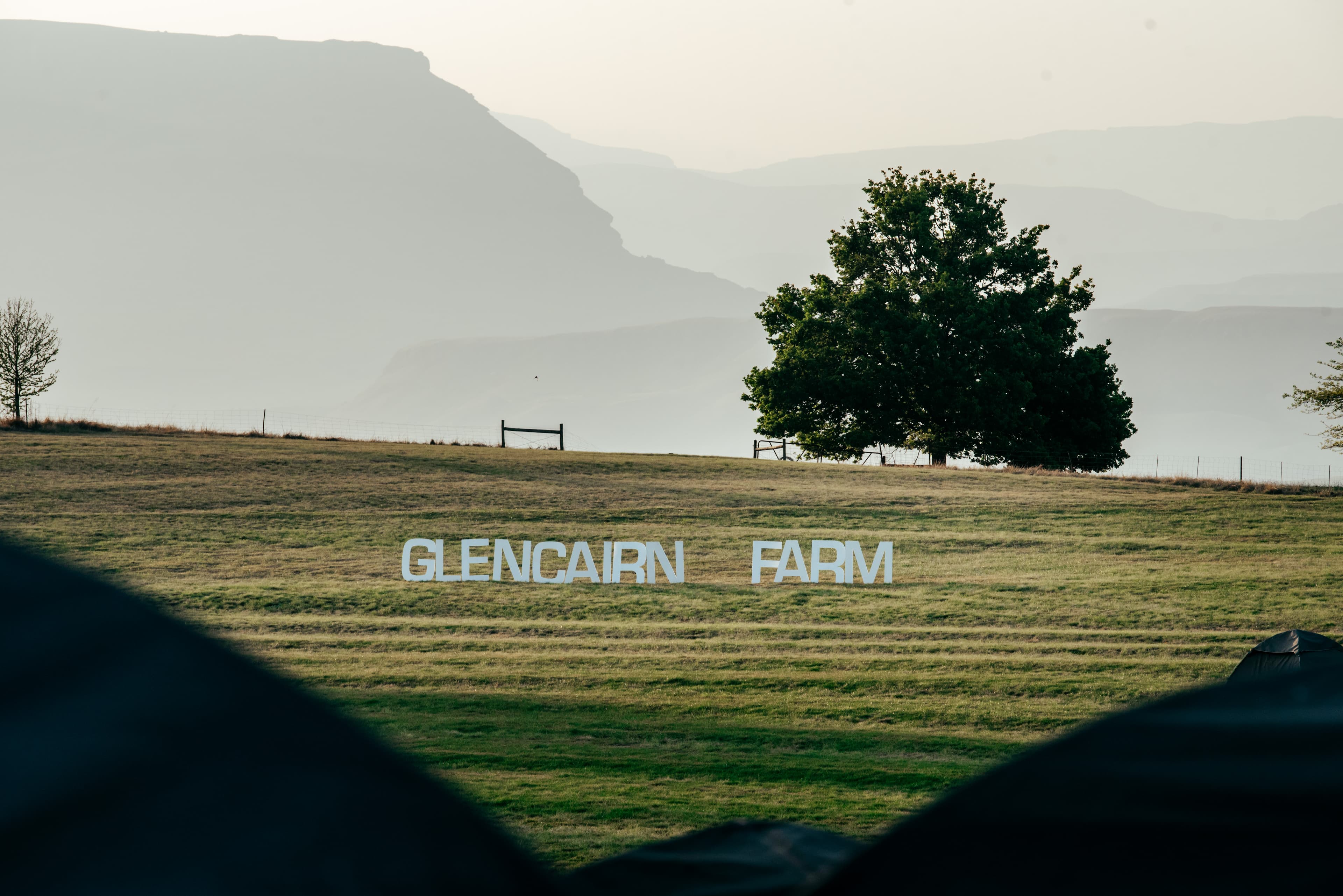 Glencairn Farm sign with tree and mountains