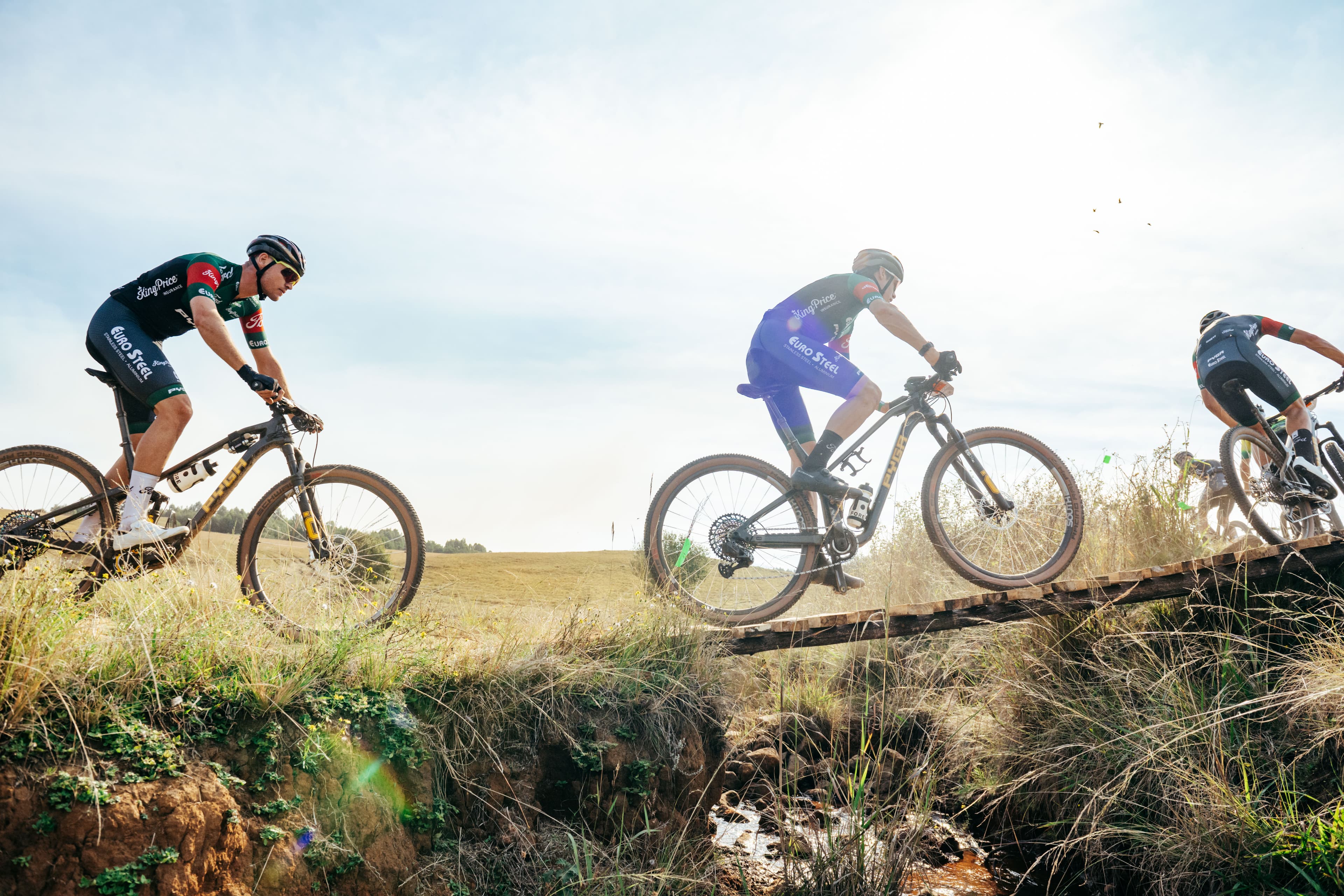 Wide shot of riders crossing bridge