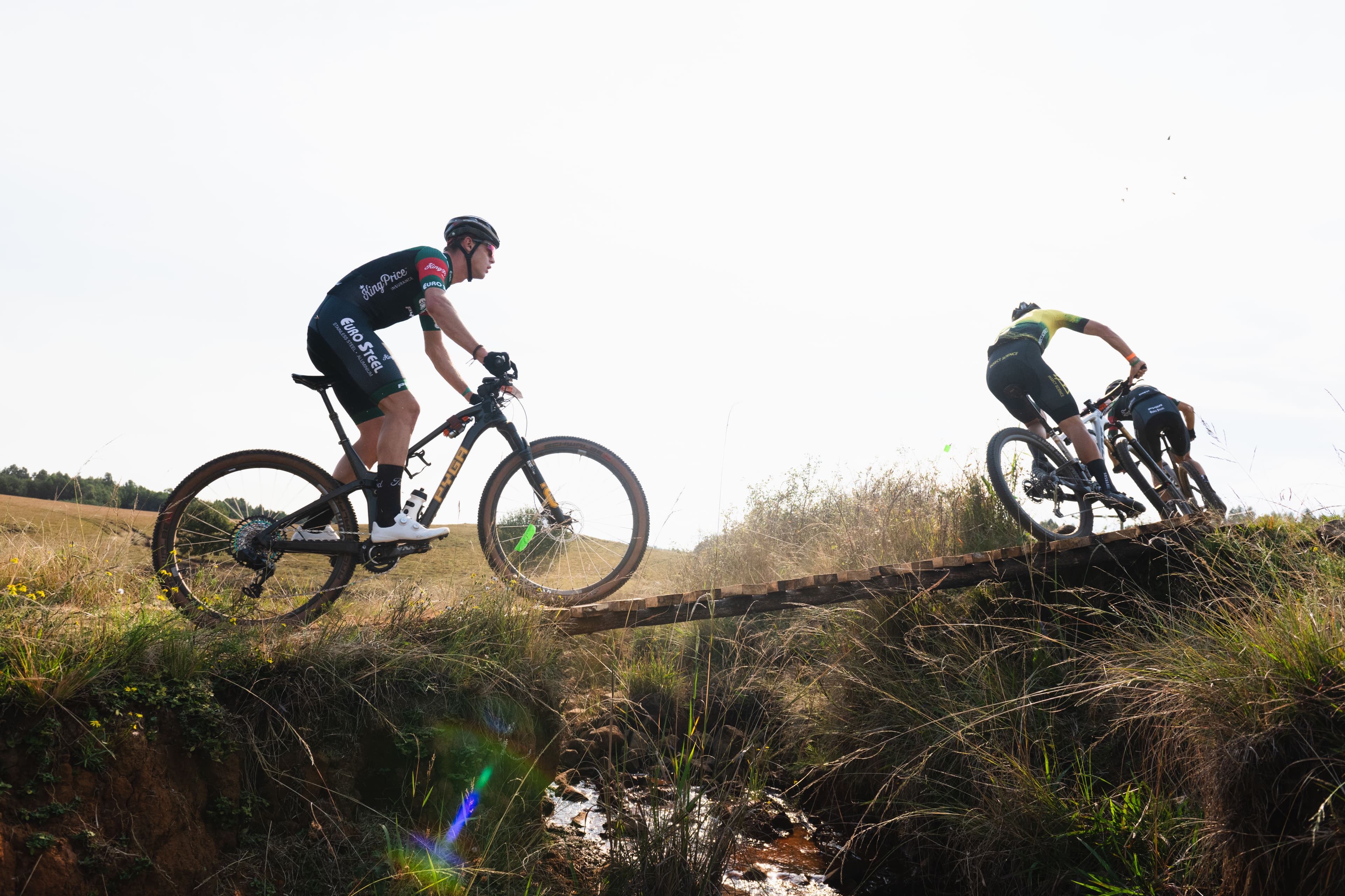 Riders crossing bridge over stream