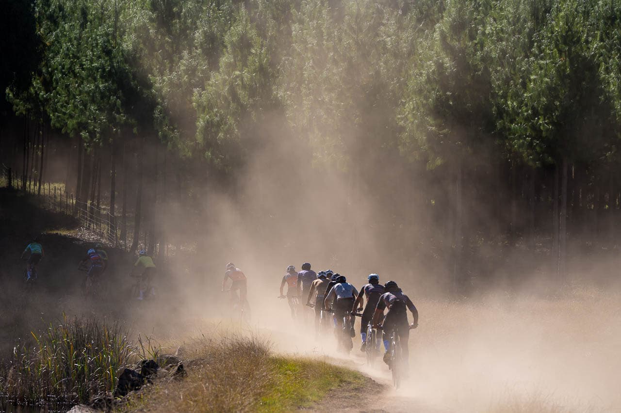 Riders on dusty trail with sun rays