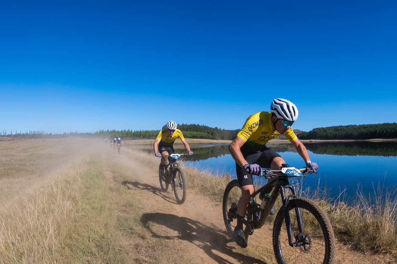 Riders on trail alongside dam