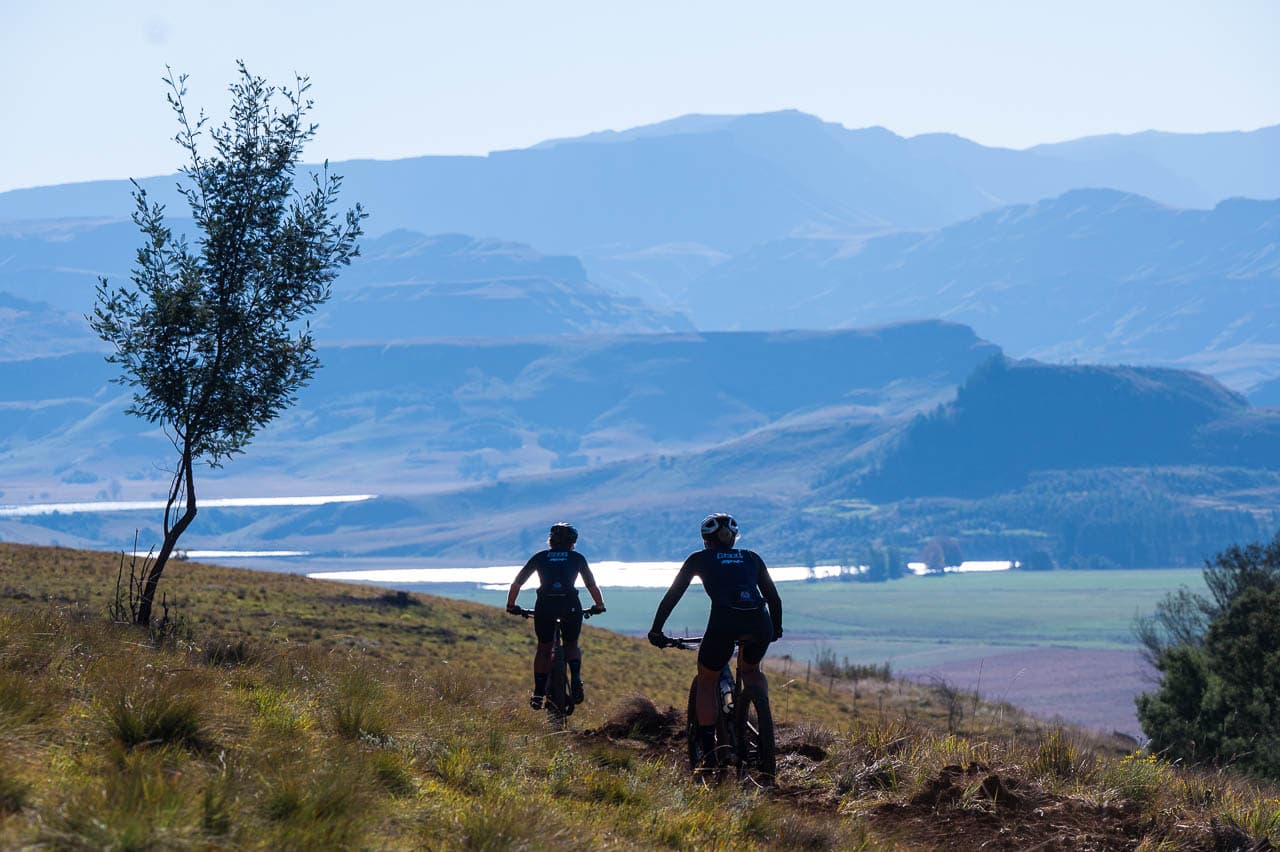 Riders on trail with Drakensberg vista